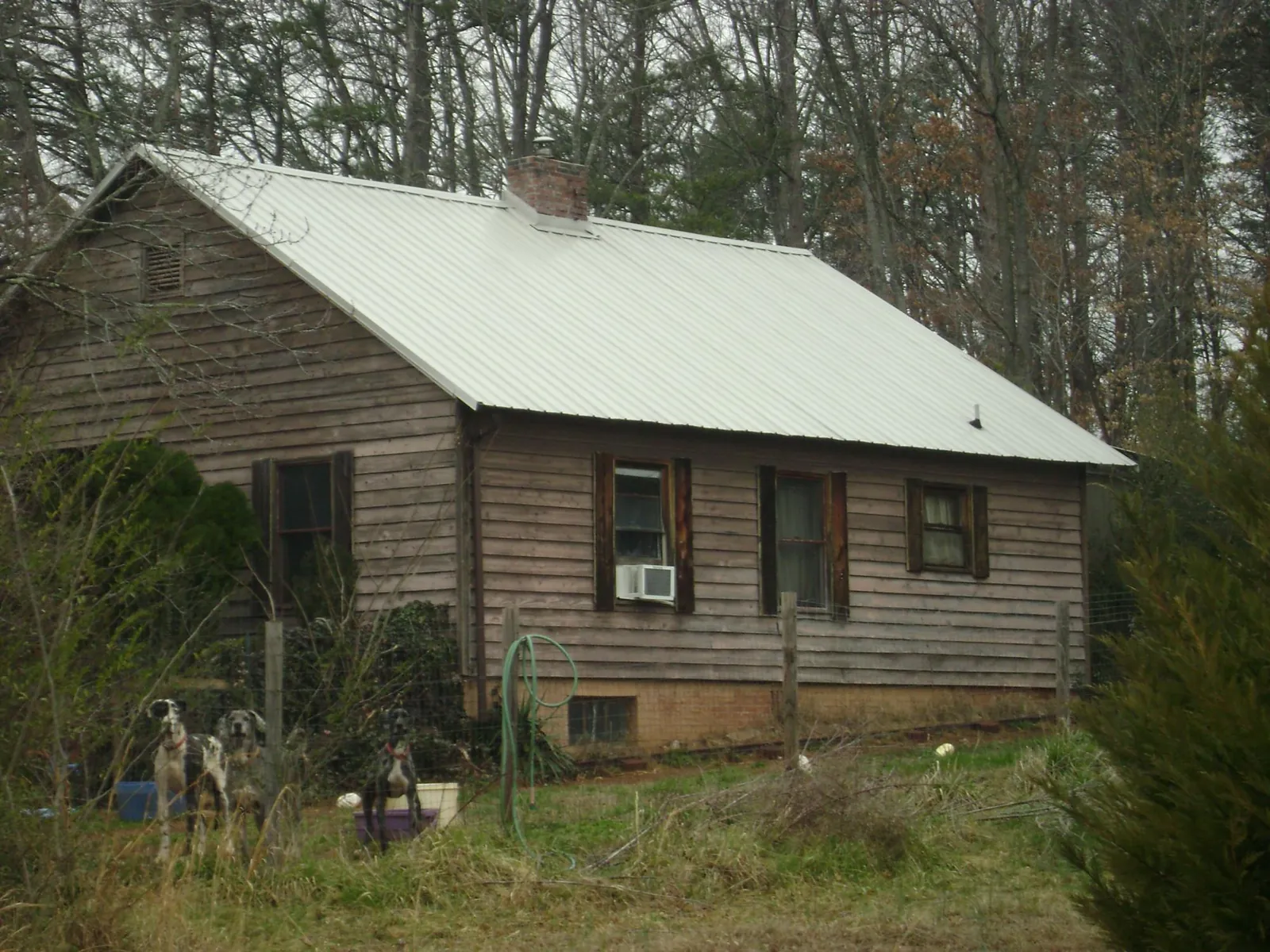 White metal roof on an old wood sided farmhouse, from a Metal Roof Installation job in Lewis
